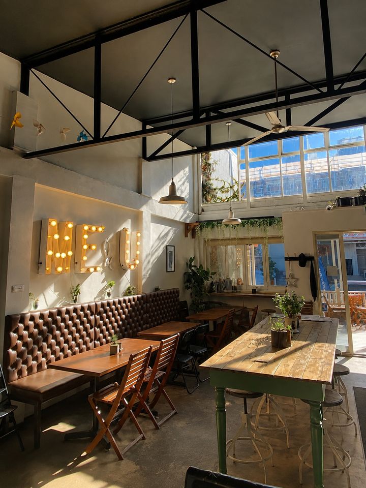 Sunlit communal tables and the Me & You sign inside the cafe